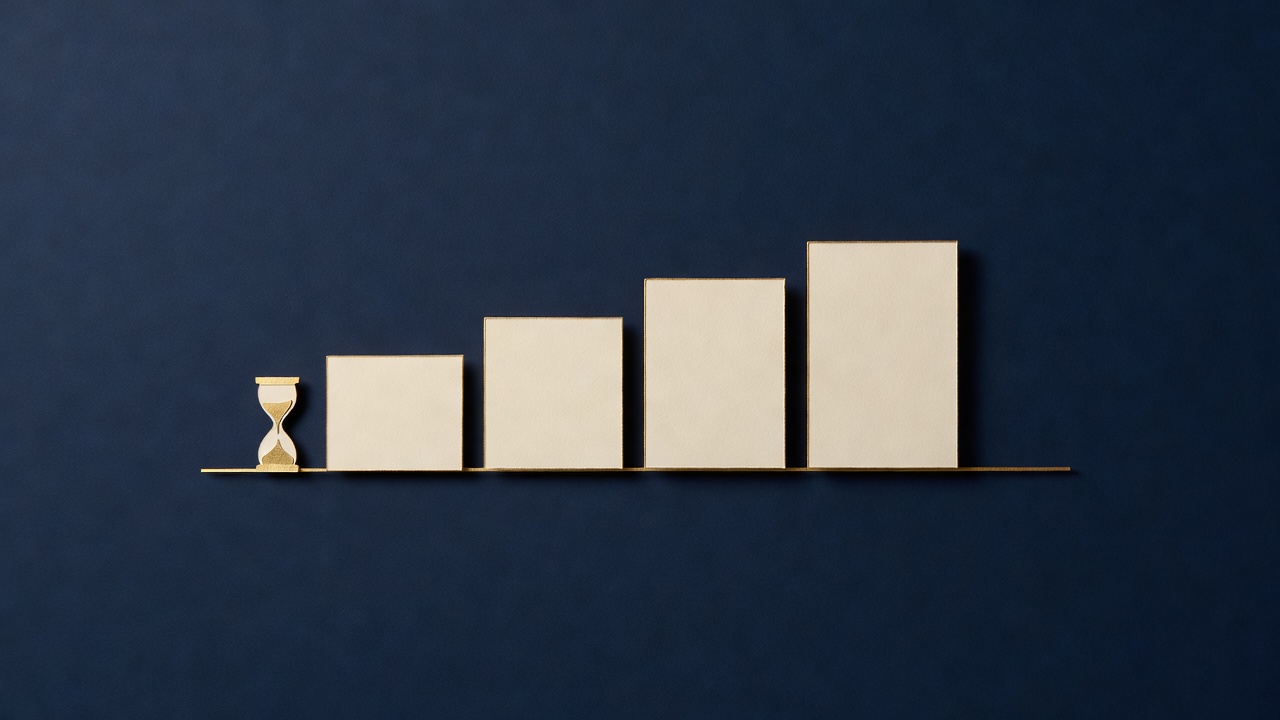 Paper-cut still life of four blank cards rising like steps beside a small paper hourglass on navy
