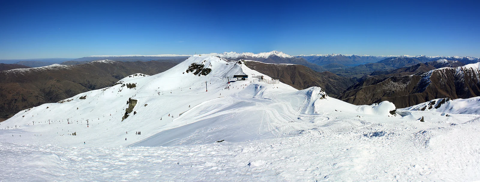 Archive panorama of snow-covered Captains Basin at Cardrona, with a chairlift and distant mountains.