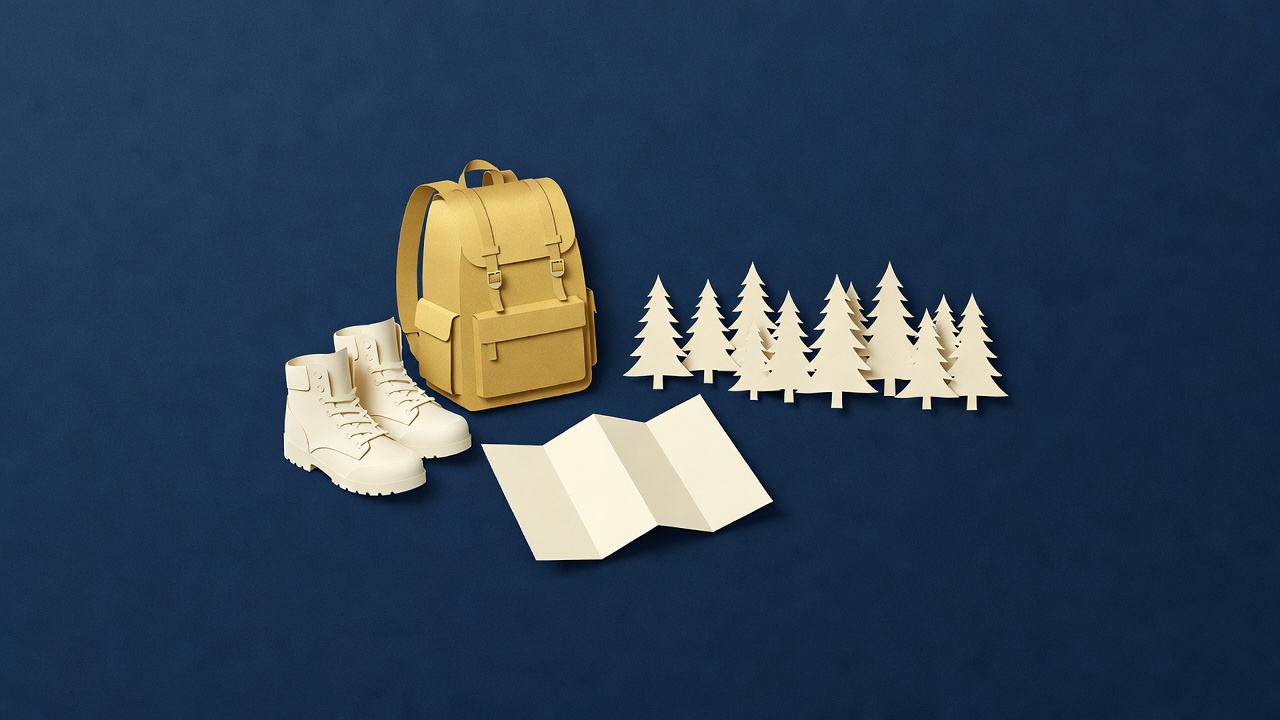 Paper-cut still life of hiking boots, a backpack, a folded map and pine trees on navy